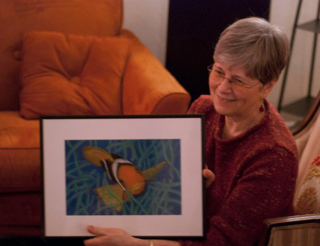 louise neilson holding painting of clown fish